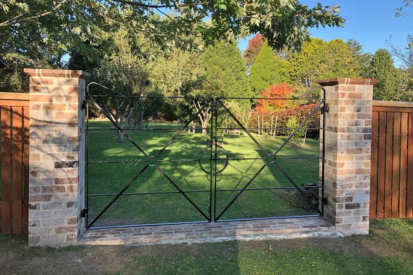 Gateway is constructed using recycled brick gate columns and customised iron gates