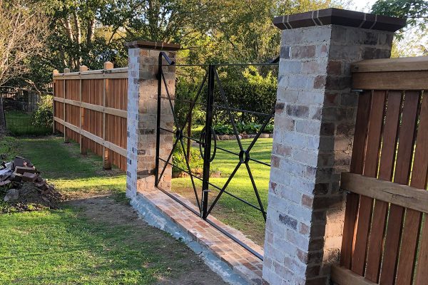 Gateway is constructed using recycled brick gate columns and customised iron gates
