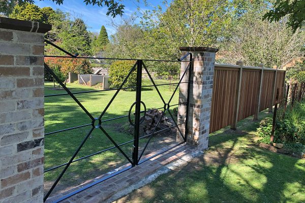 Gateway is constructed using recycled brick gate columns and customised iron gates