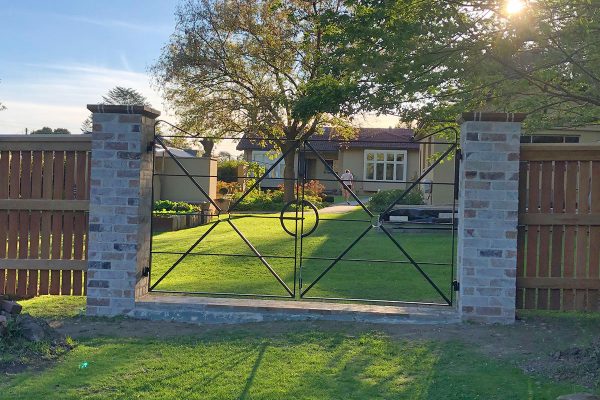 Gateway is constructed using recycled brick gate columns and customised iron gates